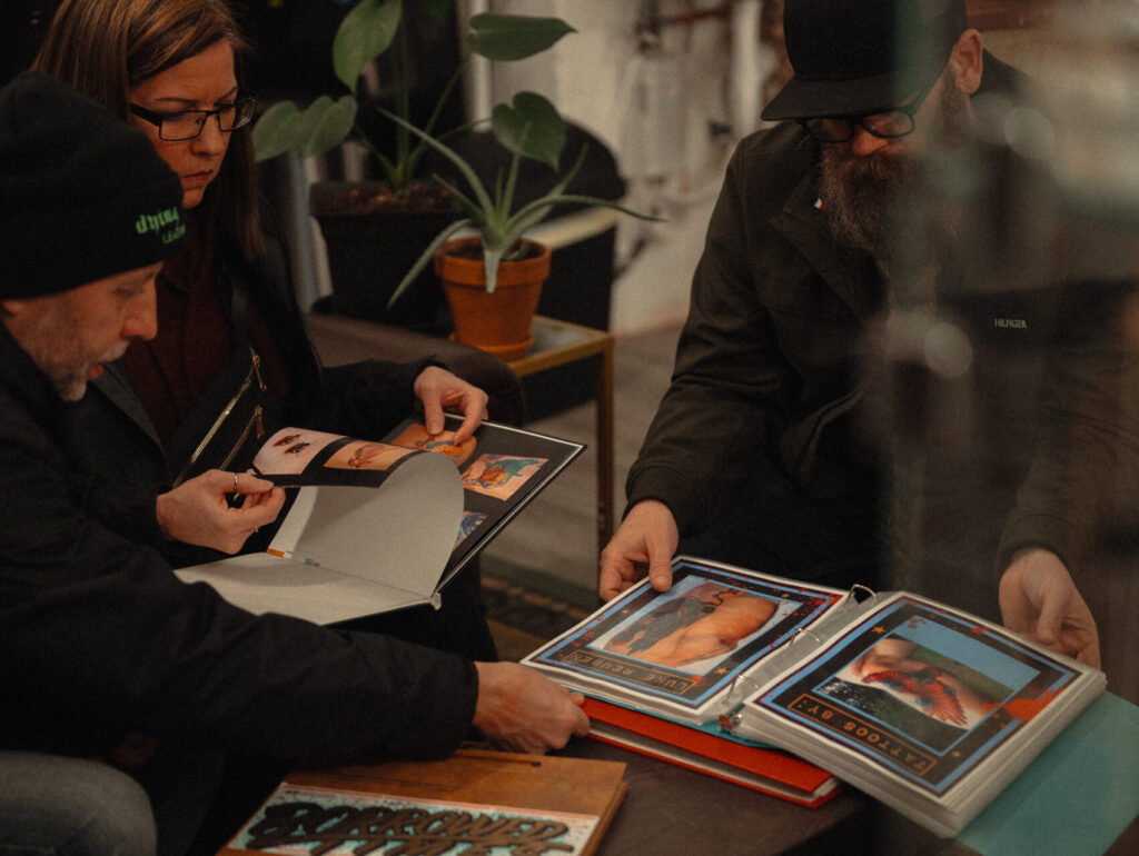 Clients at the Witching Hour Tattoo and Gallery looking at the extensive portfolios